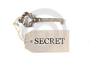 Old antique key with a label and the word secret isolated on white background with copy space