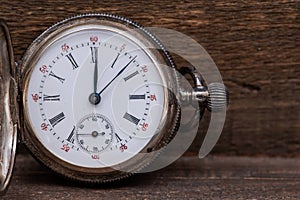 Old antique pocket watch on natural wood