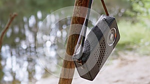 Old Antique Radio in a Leather Case Weighs on a Tree Branch in Forest in Nature