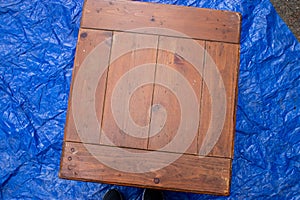 Old antique table set out on a blue tarp