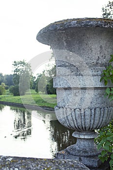 Old antique vase outside in green park, landscape view