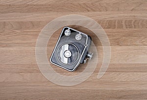 Old antique vintage film camera on wooden background. Retro photo lens on wood desk, top view with copy space around