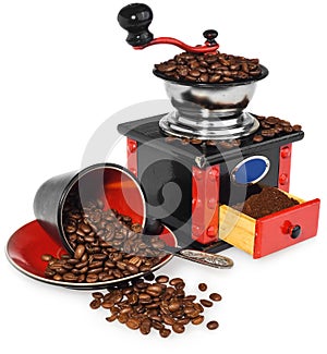 Old antique wooden black and red coffee grinder, cup, silver spoon and spilled coffee beans.