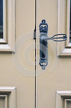 Old antique cream colored door with elegant decorative door handle