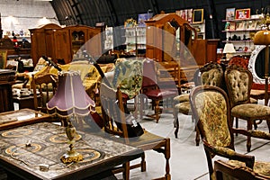Old antique wooden furniture (mirror, tables, chairs) in an antique shop
