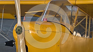 old antique yellow airplane with wooden propeller (close up of cockpit) retro aviation plane detail