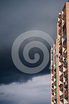 Old apartament flat building skyrise on dark stormy sky background photo