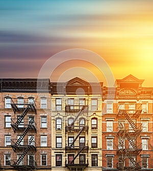 Old apartment buildings in the East Village neighborhood of New York City with colorful sunset sky background