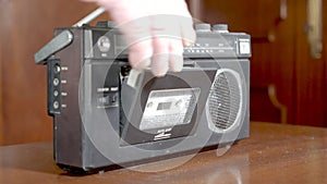 Old appliances,  loading an audio music cassette tape inside a radio player