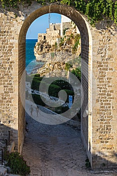 Old arch on a path leading to an ocean view on the coastal town of Polignano a Mare, Apulia, Italy photo