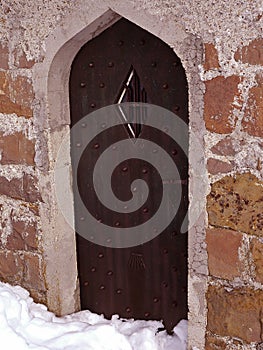 Old arched church door at winter time