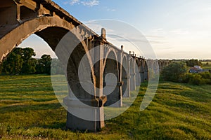 Old arched railroad bridge at sunset photo