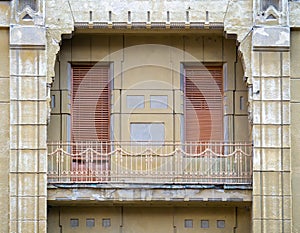 Old architectural detail of a elegant balcony with wooden shutters covering the windows in Timisoara, Romania