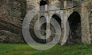 Old architecture castle exterior stone walls and arch shape of bridge green grass meadow foreground