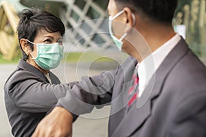 Old asian business people greeting togather by new methode with mask for prevent covid 19