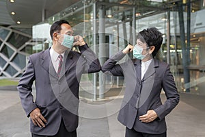 Old asian business people greeting togather by new methode with mask for prevent covid 19