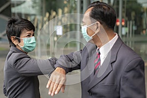 Old asian business people greeting togather by new methode with mask for prevent covid 19