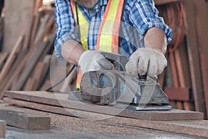 An old Asian carpenter is working to order in his own wood factory. With peace of mind by using hand tools including saws, wood