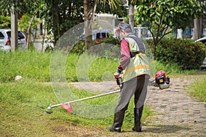 An old Asian gardener`s man post with lawnmowers before working in the garden