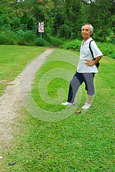 Old Asian hiker at start of hiking trail