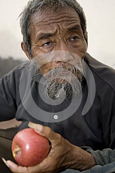 Old asian man with apple