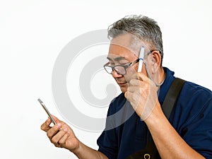 Old Asian man look at mobile phone and think something