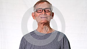 The old Asian man smiled happily showing his missing teeth and holding dentures in his hand. Health and dental care concept