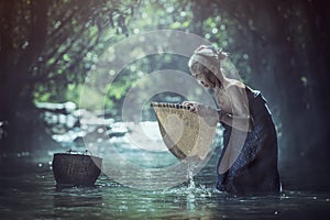 Old Asian woman working in creek