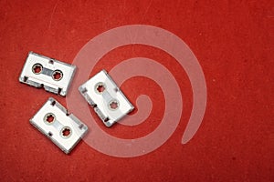 Old audio tape cassette isolated on red background