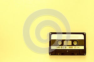 Old audio tape cassette, top view. Old technology concept. Yellow color