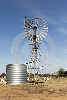 Old Australian Windmill Pumping Water In Desert Landscape