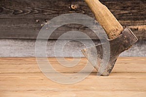 Old ax with a wooden handle stuck in wooden log. Concept for woodworking or deforestation. Selective focus.