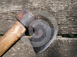 Old axe with sharp blade on wooden planks, weathered rusty steel hatchet, rustic iron equipment, tool and weapon