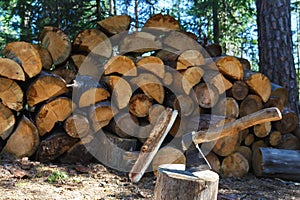 Old axe standing against a piled pieces of firewood