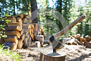 Old axe standing against a piled pieces of firewood