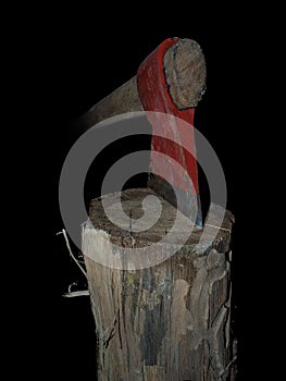 Old axe stuck in log isolated over black