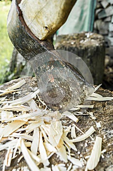Old axe is stuck in a stump, close-up abstract background