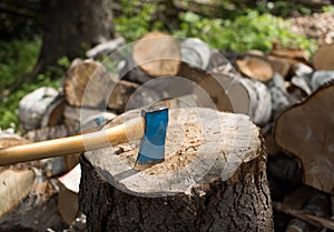 Old axe in the top of a chopping block