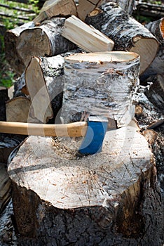 Old axe in the top of a chopping block