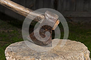 Old axe on a tree stump for chopping firewood.