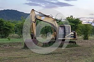 Old backhoe on construction site in the green fields