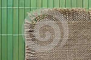 Old backing of burlap on the green bamboo mat