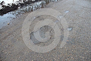 Old bad asphalt road with holes in a countryside