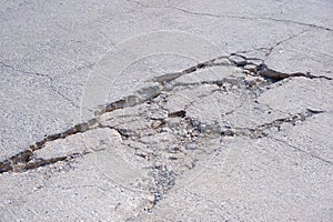 The old badly damaged concrete street background with collapsed and broken crack texture on surface