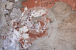 Old badly damaged gray concrete wall with spots of red and white paint. rough surface texture
