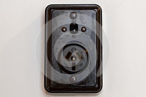 An old bakelite New Zealand power socket with an on and off switch