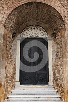 Old balck door in brown wall. Vertical color photography photo