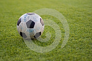 Old ball soccer on new green grass-ground