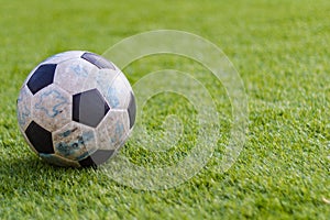 Old ball soccer on new green grass-ground