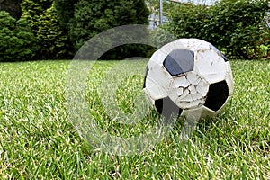 Old ball to play football, detail of the sport on the grass